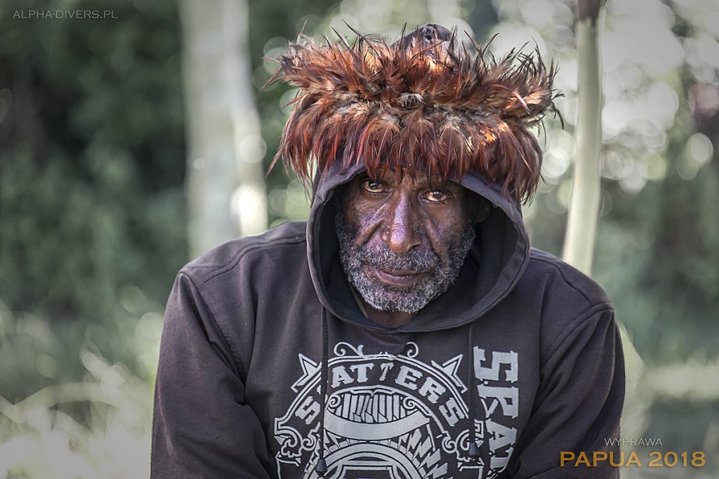 Połączenie tradycji z nowoczesnością. Papuaski wojownik w tradycyjnym nakryciu głowy i bluzie sportowej. Papua-Nowa Gwinea 2018 © P. Trześniowski