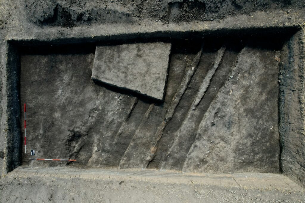 Plan wykopu 1 (2023) na stanowisku Ciepłe 3. Widoczne są ukośne stopnie fortyfikacji z 1626 r. oraz trapezowy fragment w pobliżu południowego profilu, który jest pozostałością po wykopaliskach z lat 1973–74.© S. Wadyl, na licencji CC BY 4.0