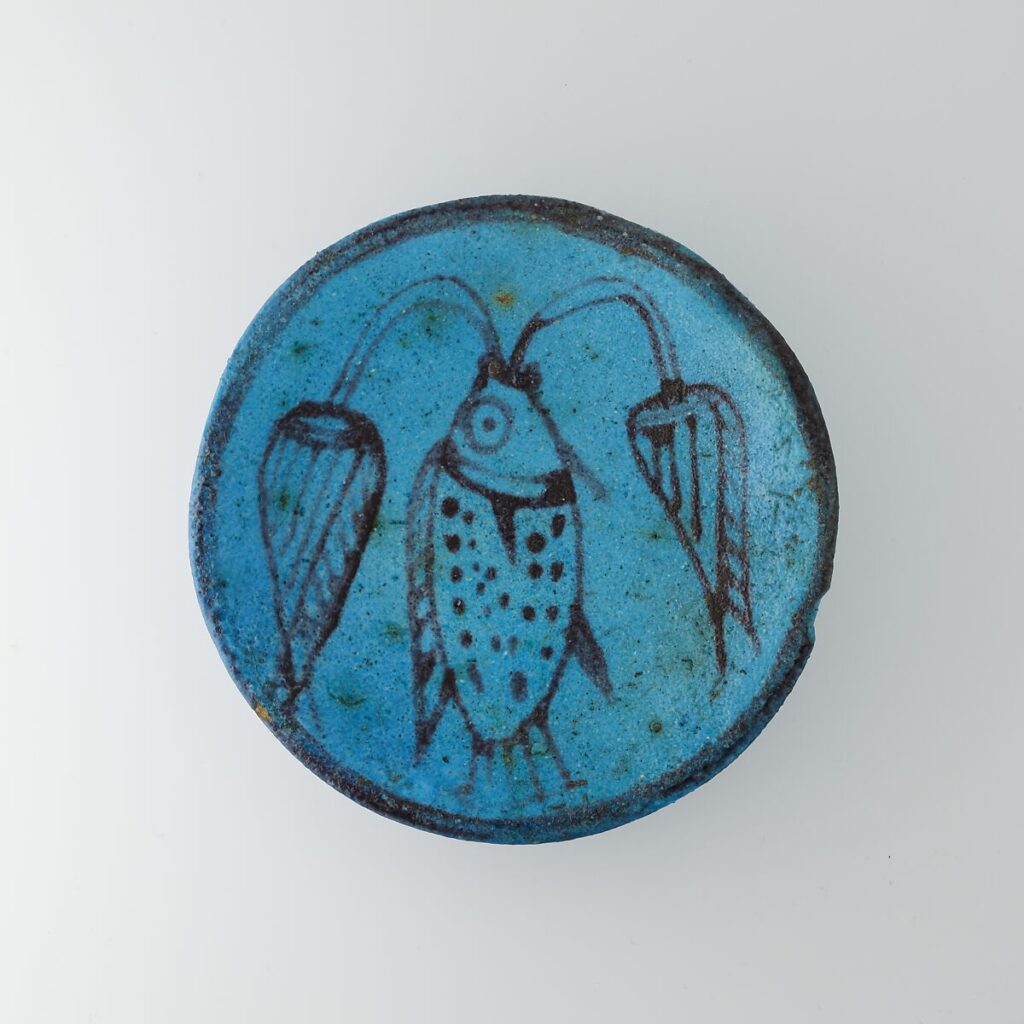 Przedstawienie tilapii na naczyniu fajansowym. Z jej pyska wychodzą dwa kwiaty lotosu, które również były wiązane z odrodzeniem.MET Museum, Domena Publiczna